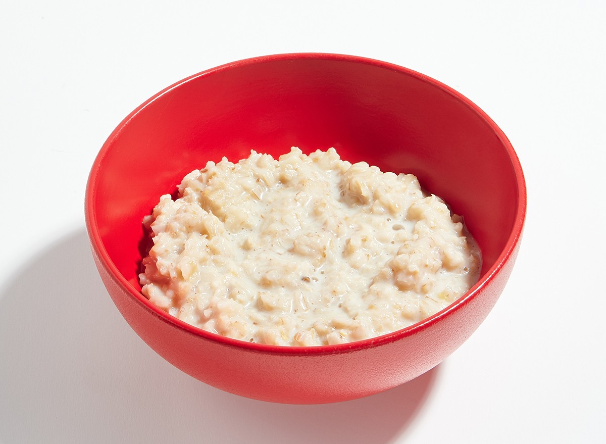 A bowl of plain instant oatmeal on a white surface