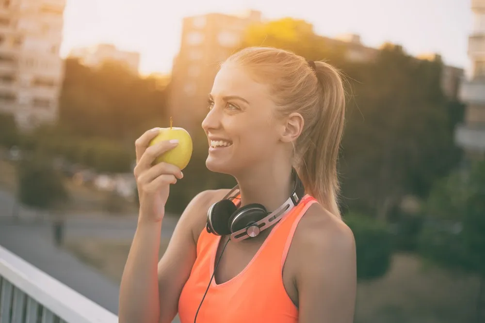 happy healthy woman eating apple