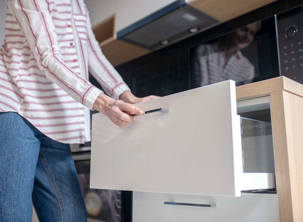 A woman opening a drawer in the kitchen