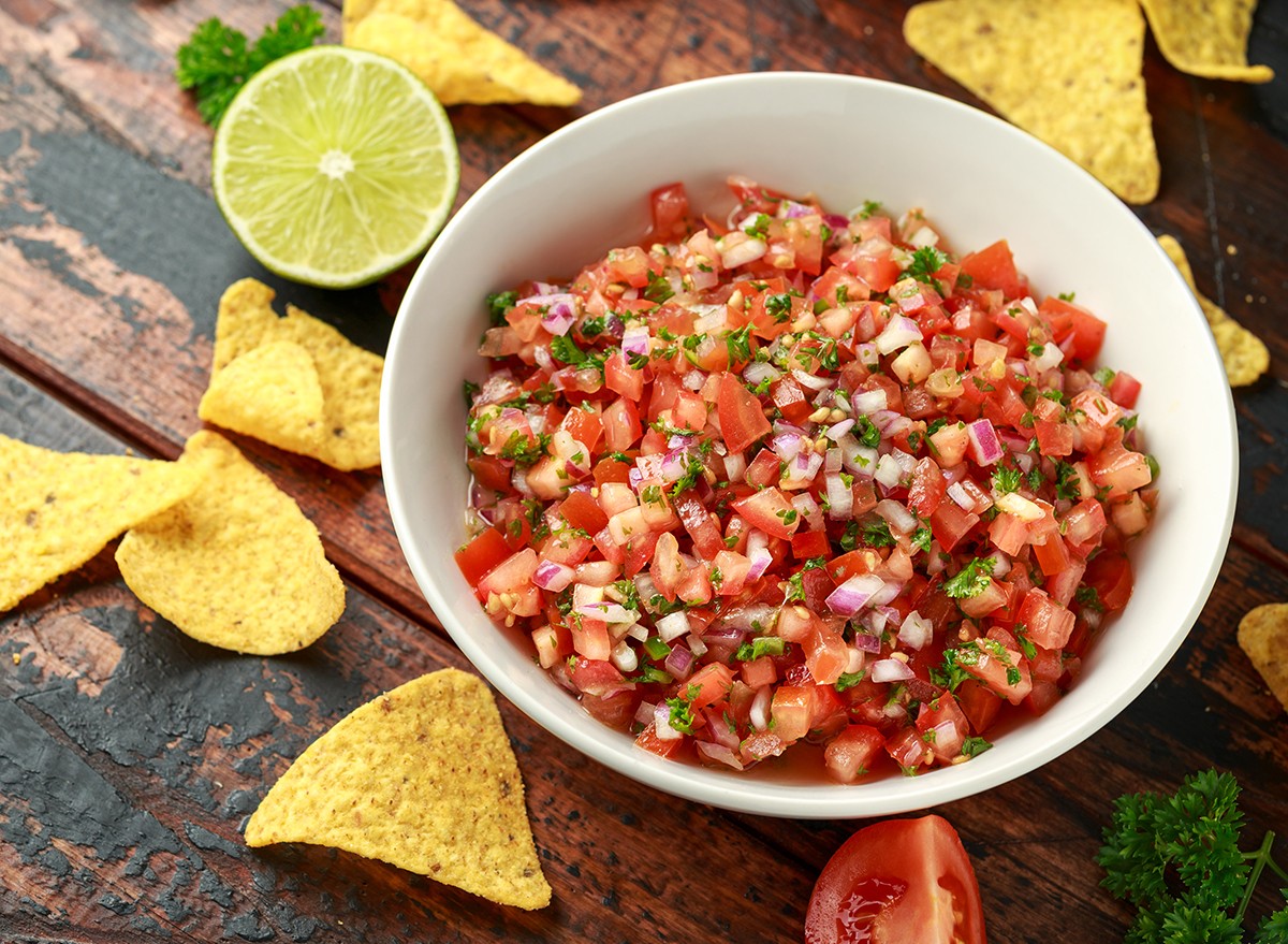 Bowl of finely chopped pico de gallo on a wooden table