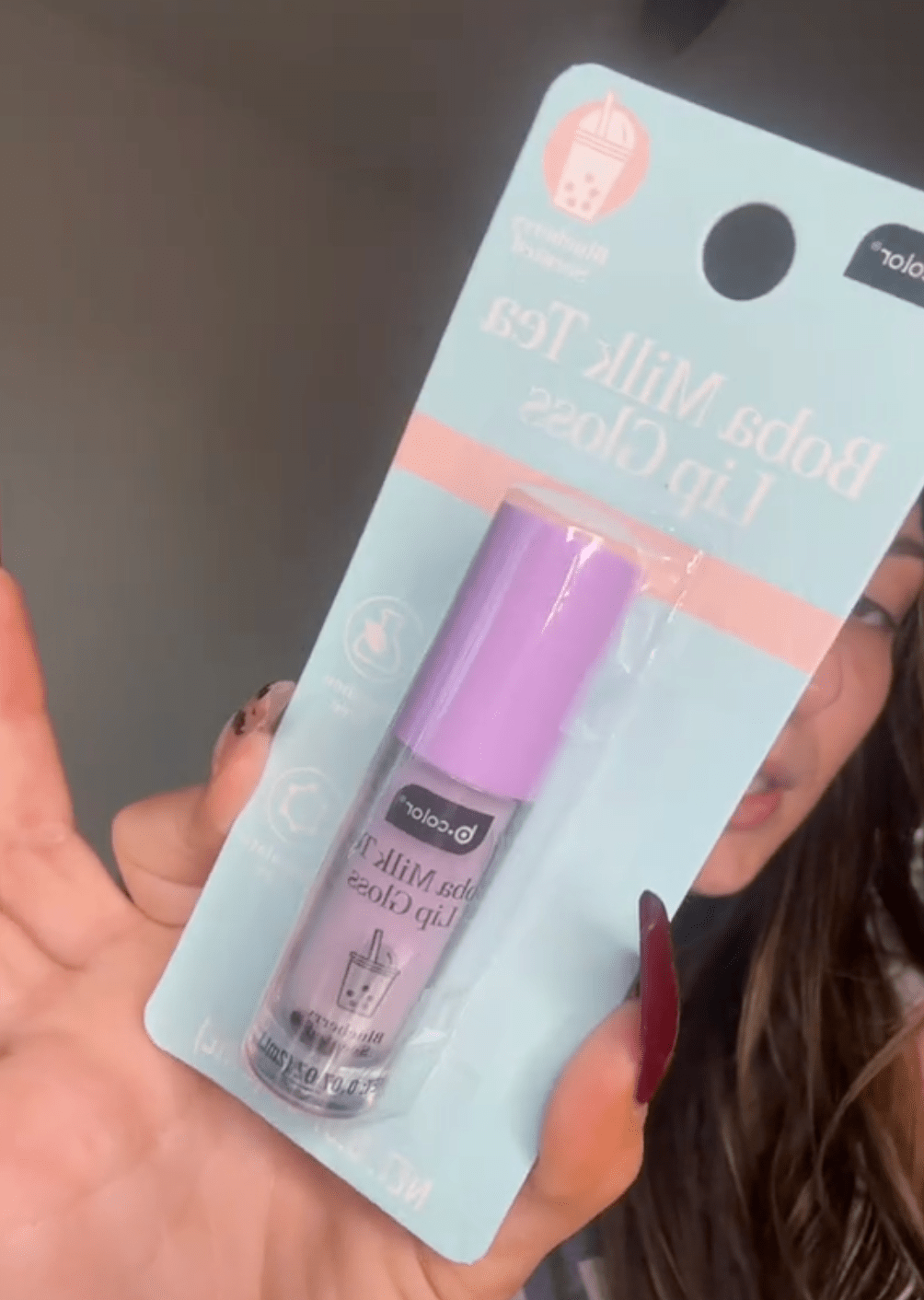 woman holding up lip gloss from Dollar Tree