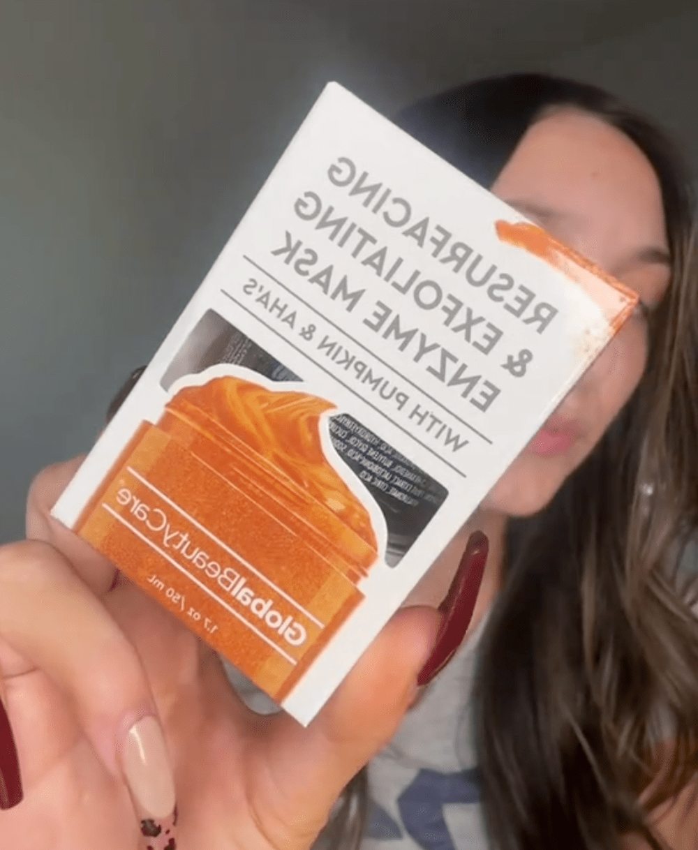 woman holding up pumpkin face mask from Dollar Tree