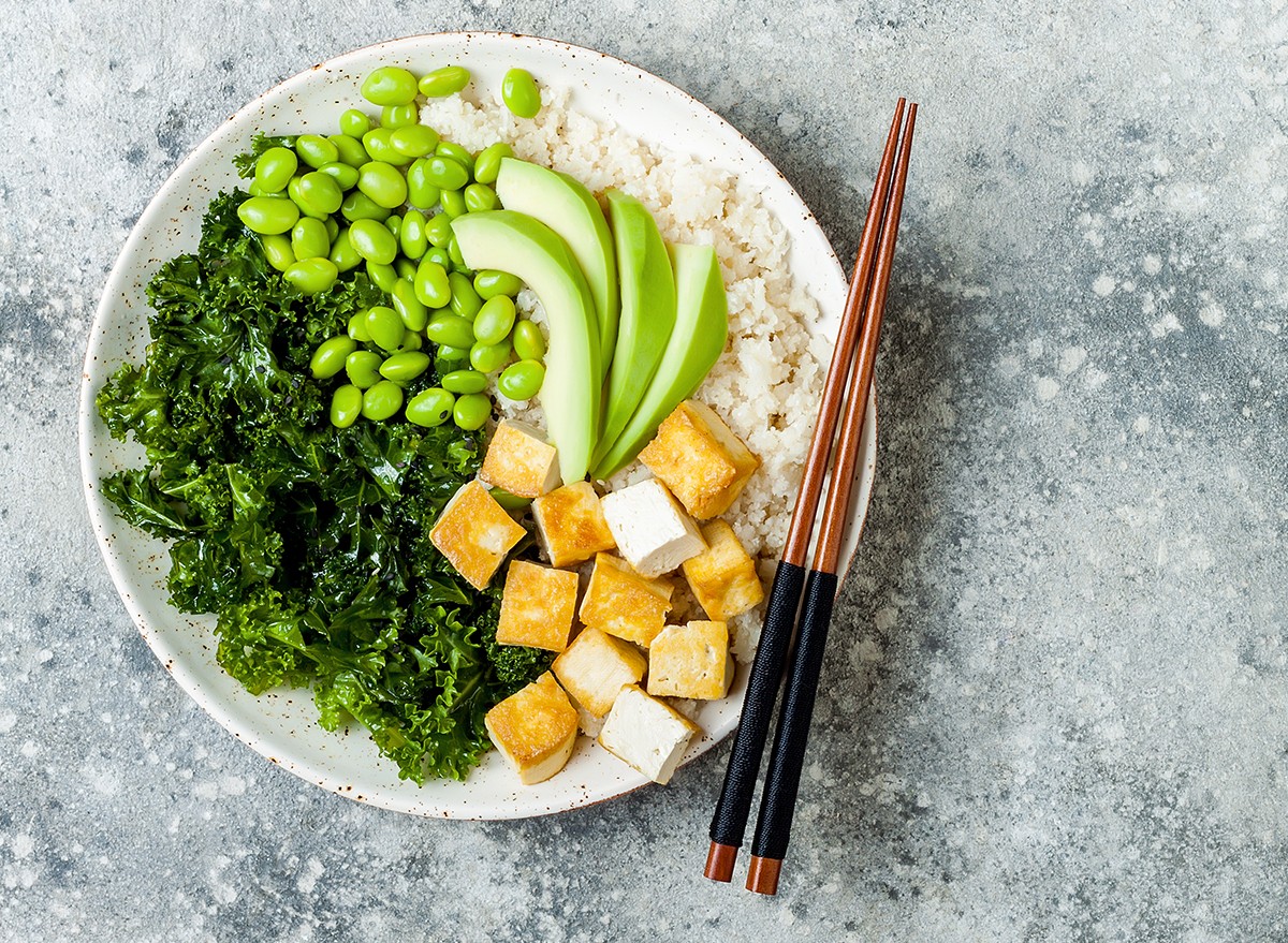 A rice bowl with kale, tofu, avocado and edamame beans