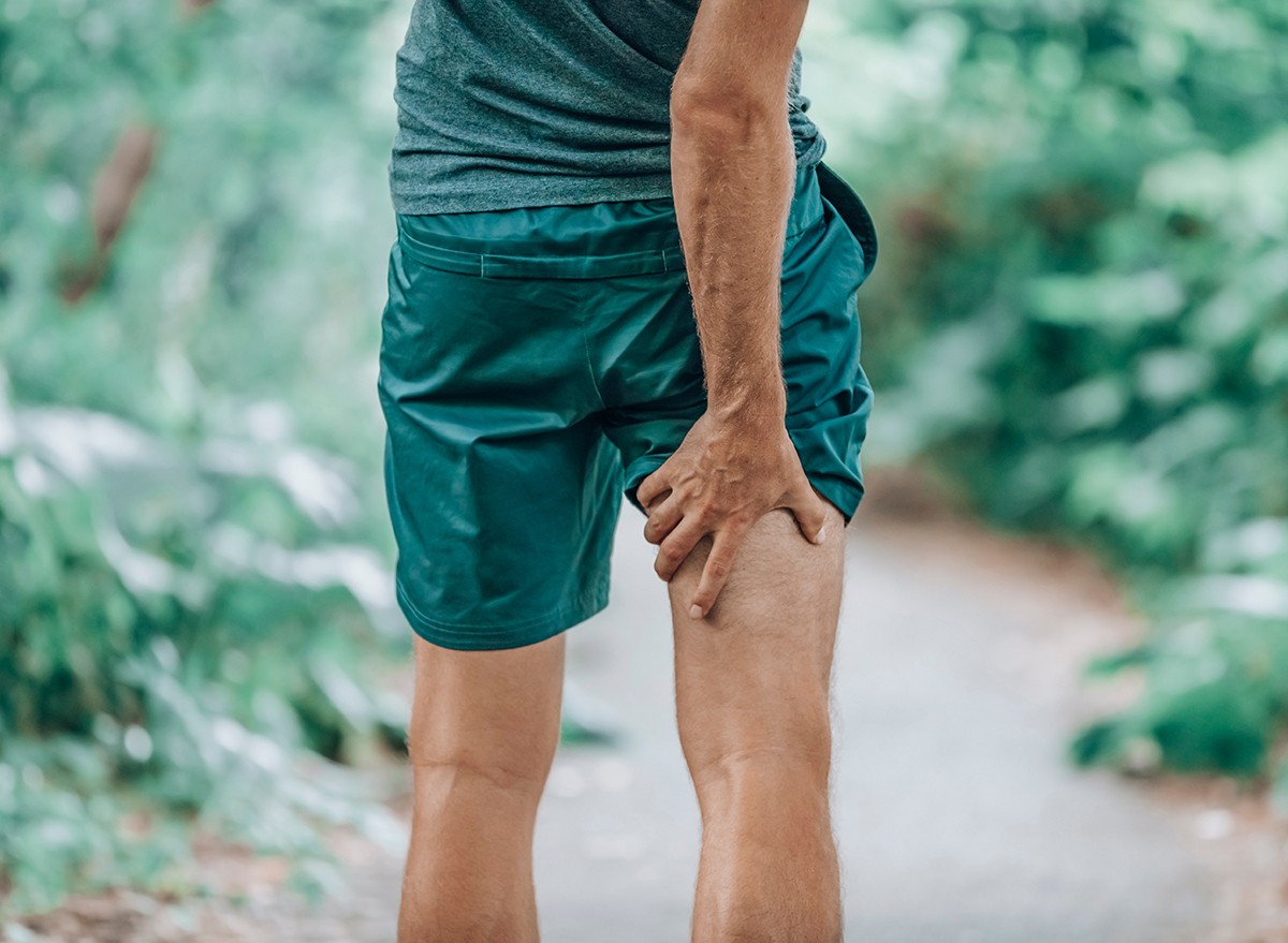 A man holds the back of his leg where he has hamstring pain