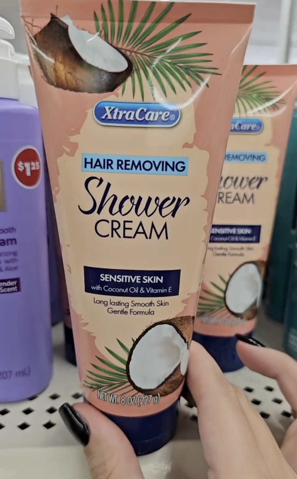 shopper holding up a bottle of hair-removing shower cream from Dollar Tree