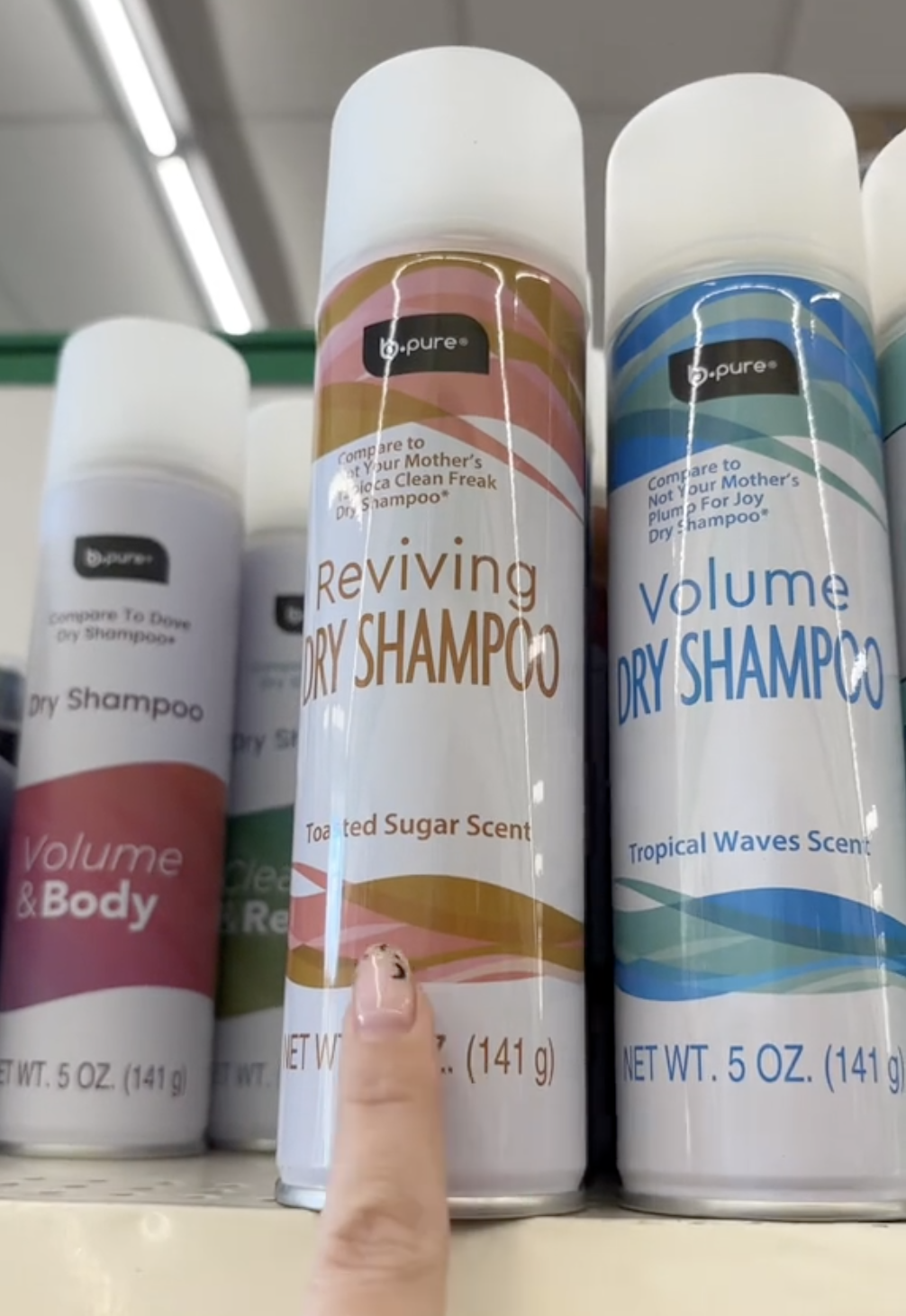 shopper pointing to dry shampoo at Dollar Tree