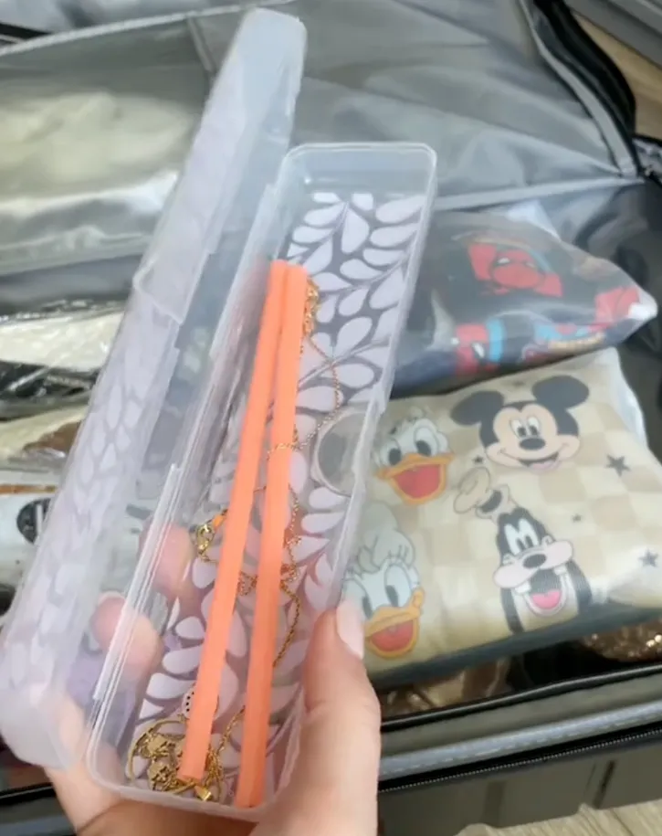 A makeup brush holder holding necklaces in a straw