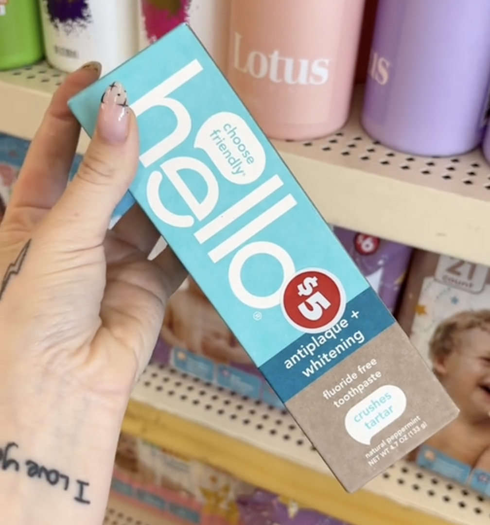 shopper holding up Hello toothpaste at Dollar Tree