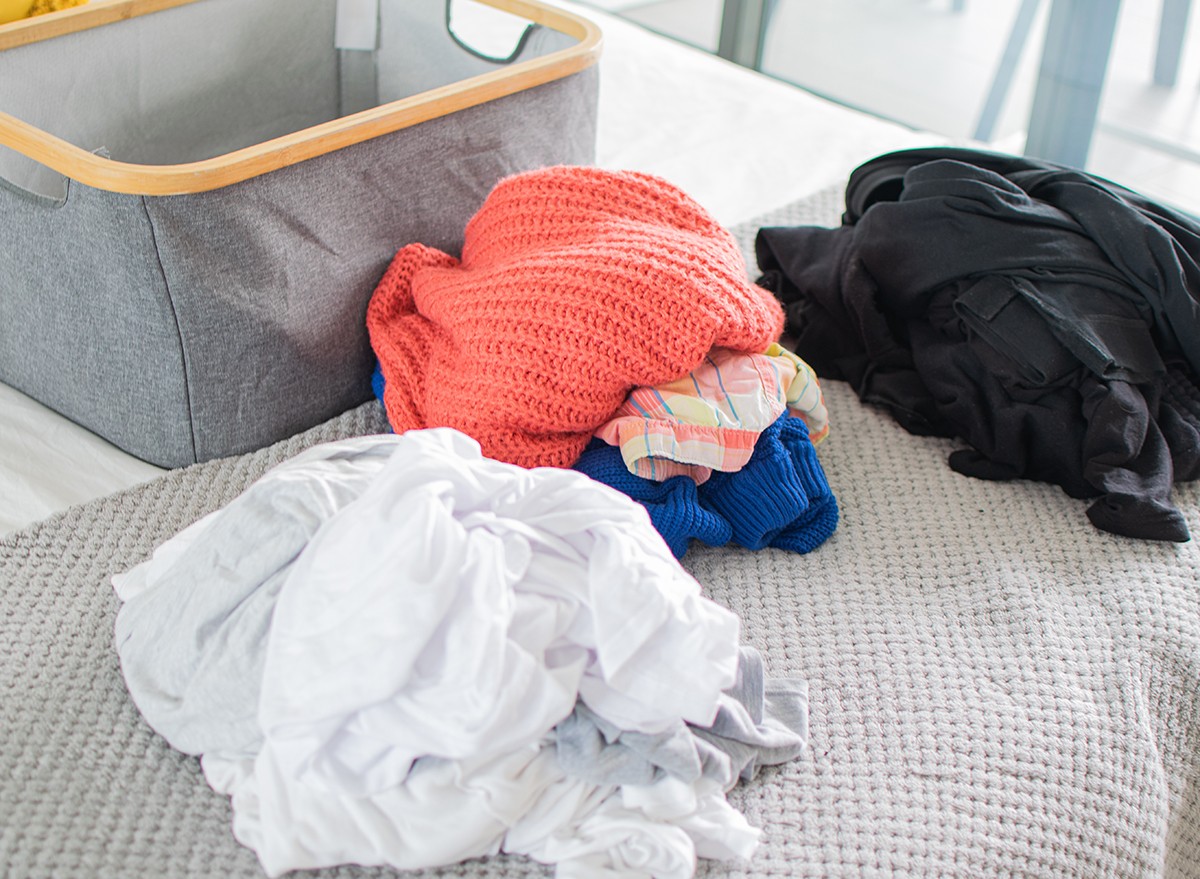 Piles of laundry on the floor separated into colors and whites