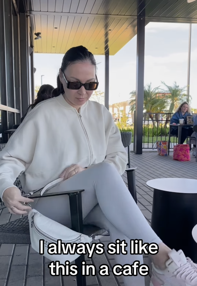 woman sitting at a cafe with her purse around her legs