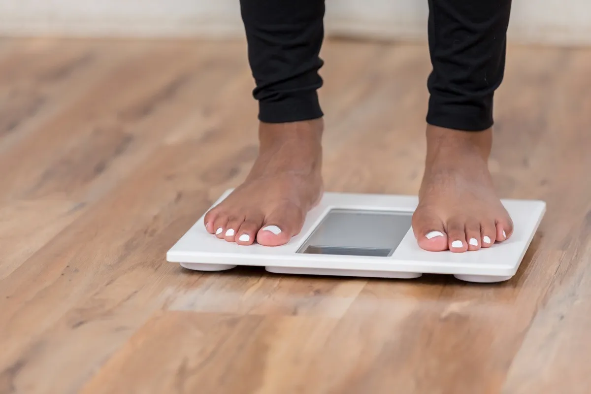 Woman weighing herself on a scale