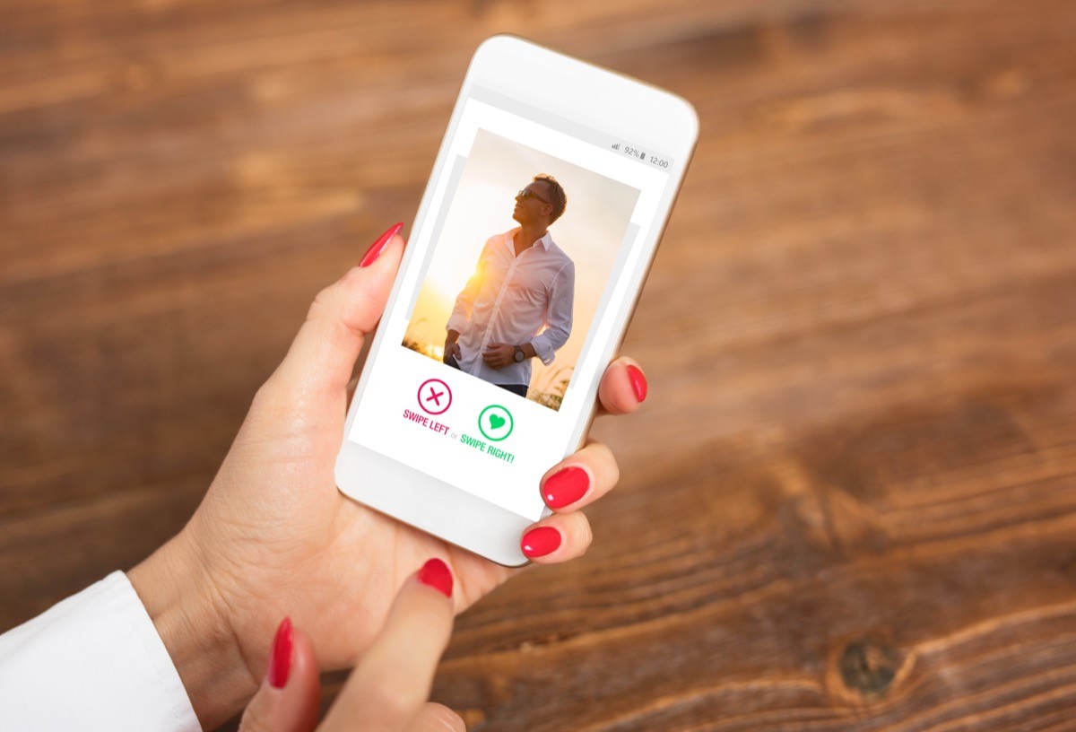 woman with red finger nails swiping on a dating app