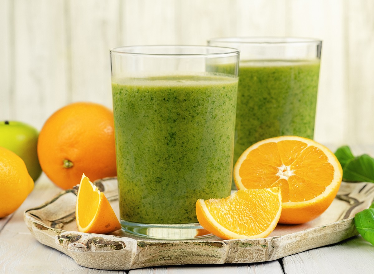 A green juice next to sliced oranges