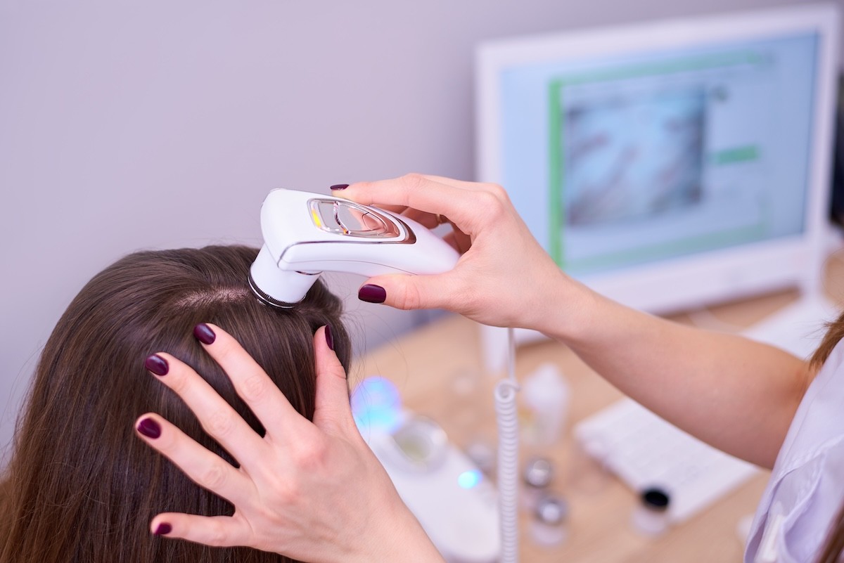 female spa therapist using a scalp camera on a female client