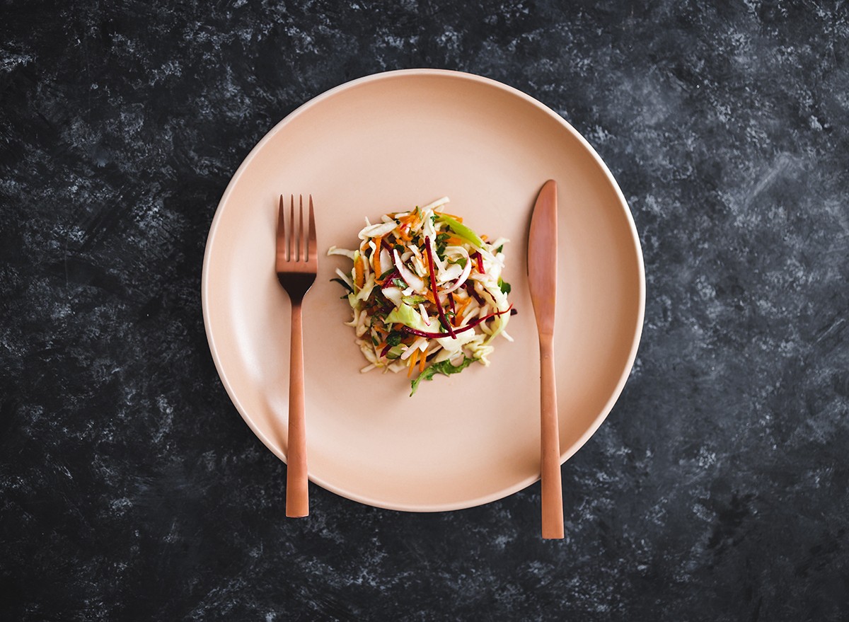 Portion control - a small plate with a salad, knife and fork