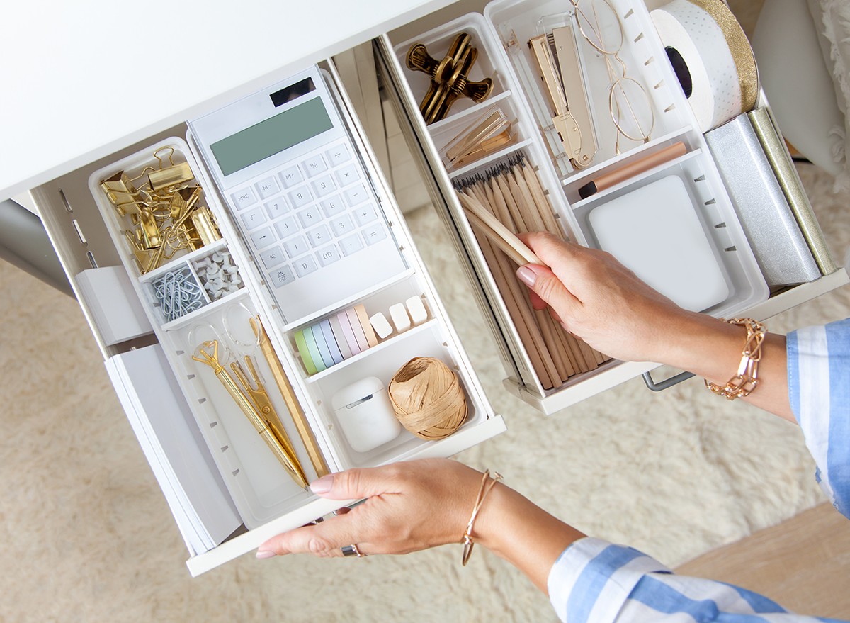 A woman arranges the things in her desk drawer using the KonMari Method