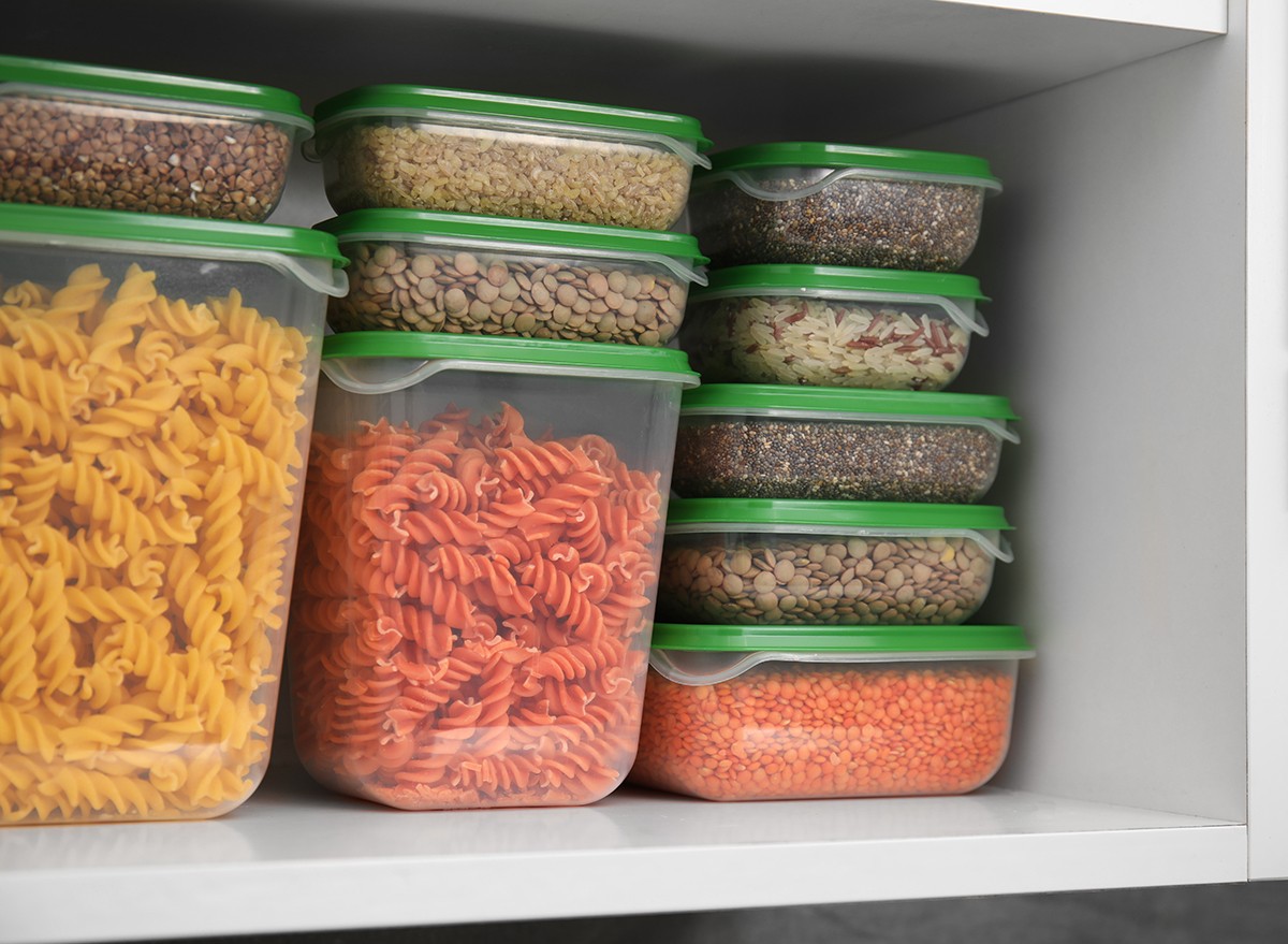 Clear plastic containers stacked on top of each other in a kitchen cupboard