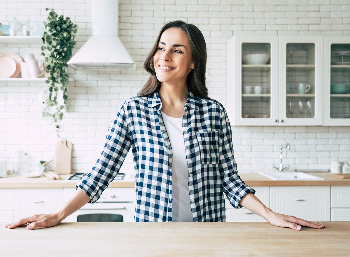 A smiling woman in a de-cluttered kitchen