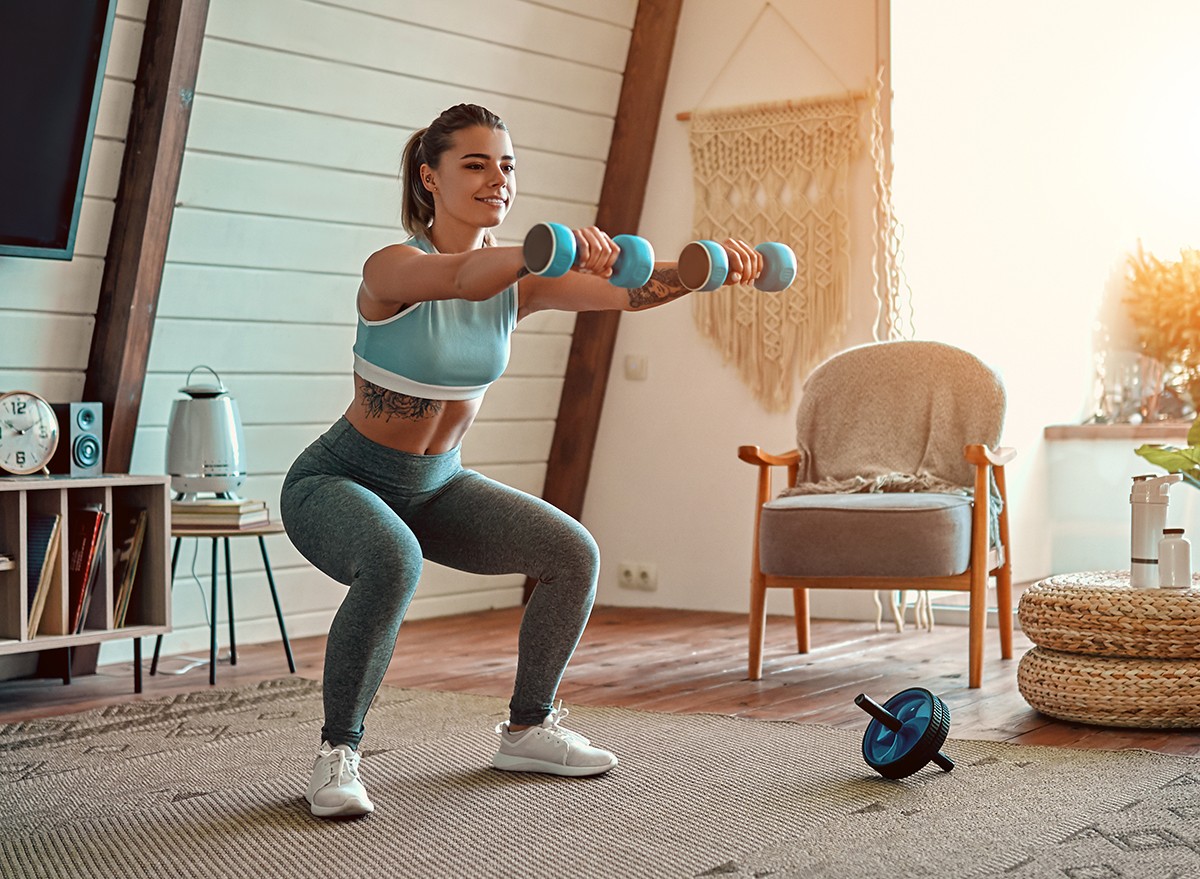 A woman working out at home with weights