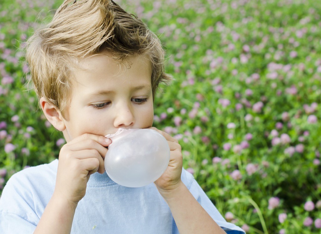 A little boy blowing a bubble with chewing gum