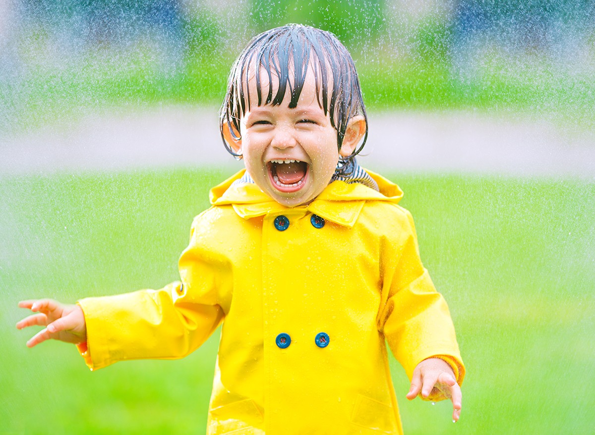 A happy little boy playing outside with wet hair