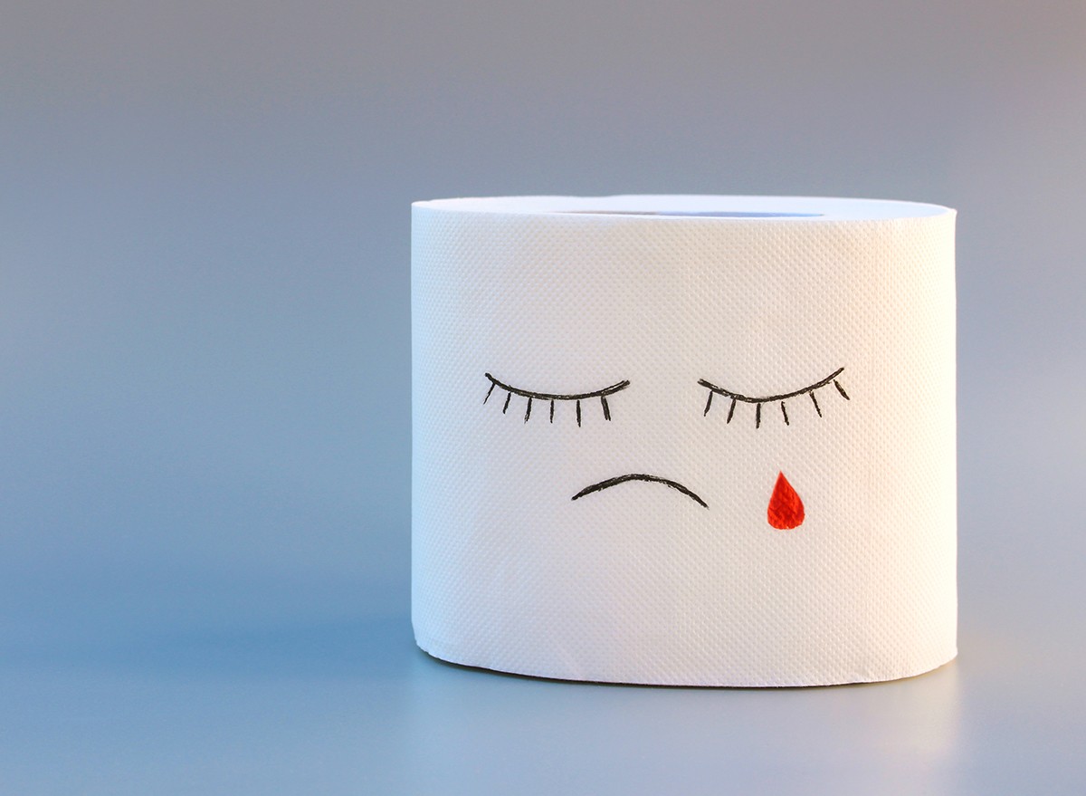 Toilet paper with sad face, concept of hemorrhoid treatment