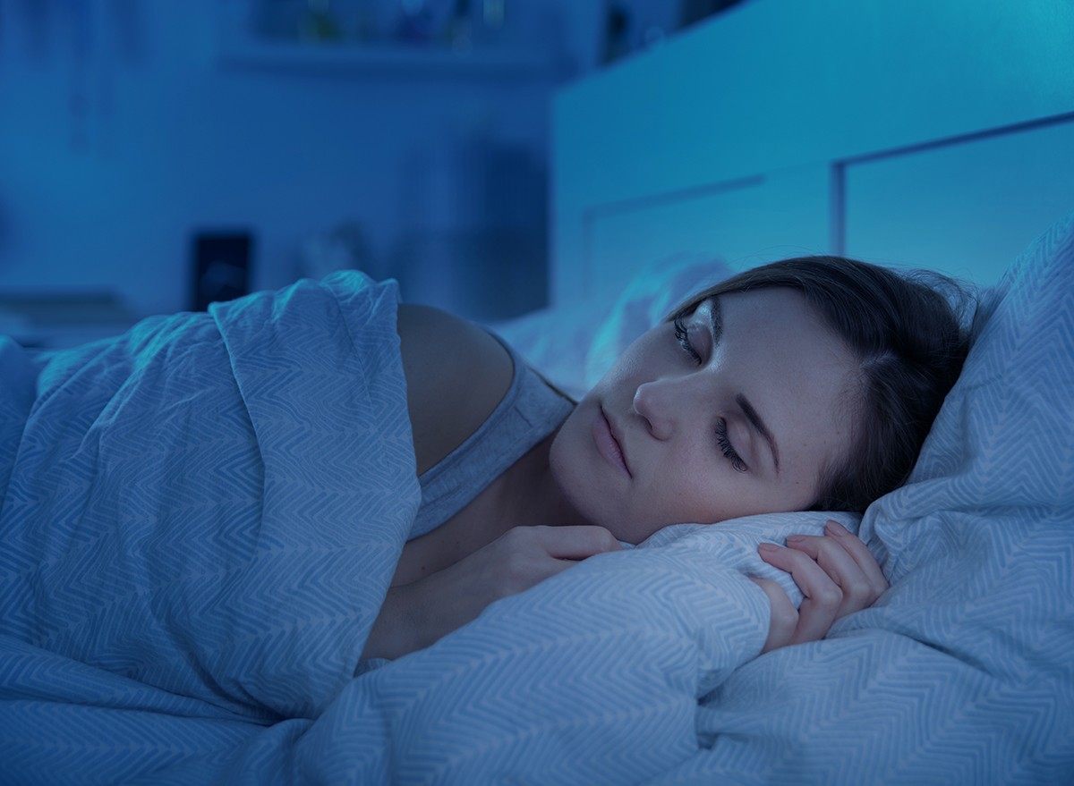 A woman sleeping peacefully in a dark bedroom
