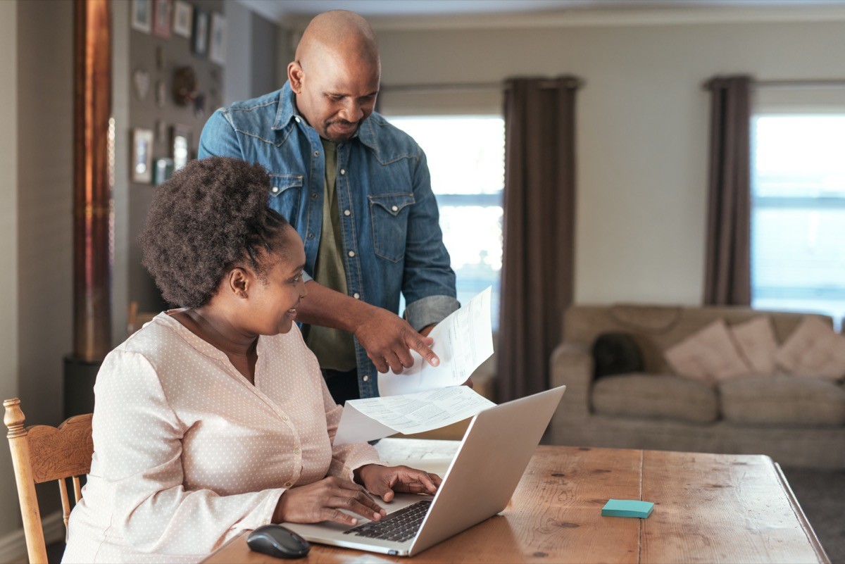 A middle-aged black couple paying bills
