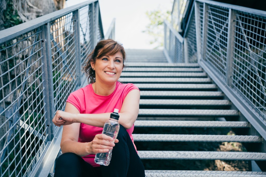 A smiling woman looks energized after a workout