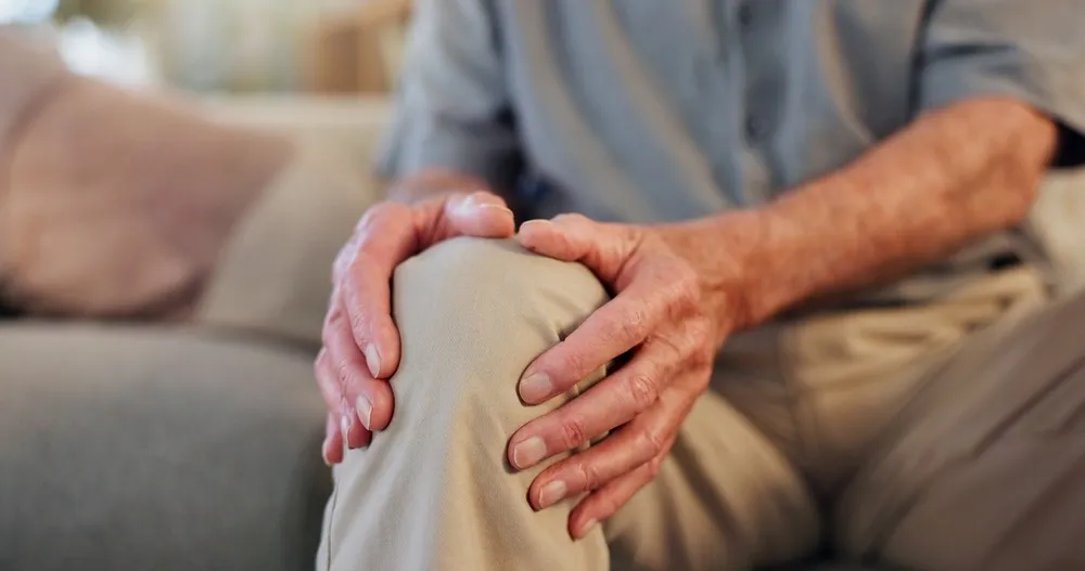 Close up of a senior man holding his knee