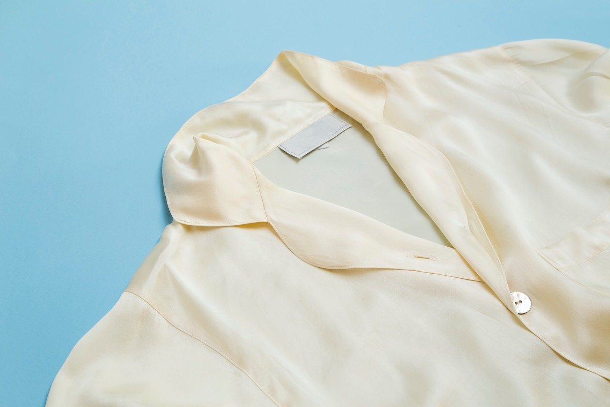 cream colored silk pajama shirt on light blue background