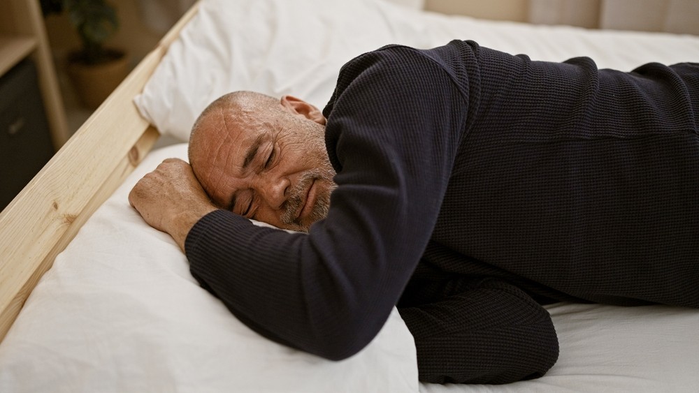 A senior man asleep in bed