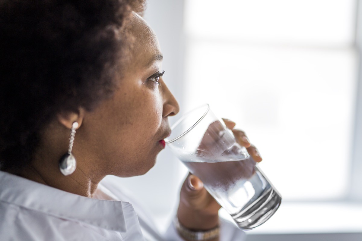 Black woman of middle age drinks water