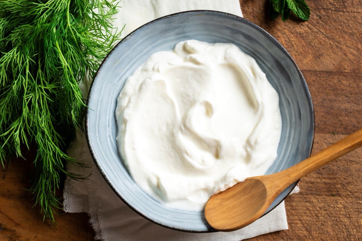 Greek yogurt in a bowl with dill next to it
