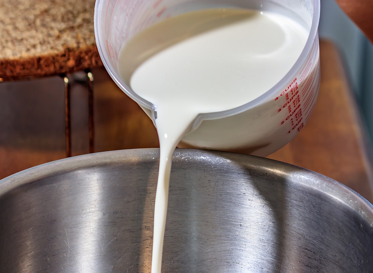 Heavy cream being poured into a metal bowl