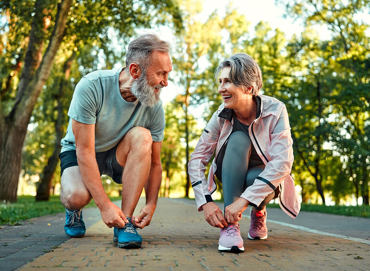 A mature couple lace up their shoes before taking a walk