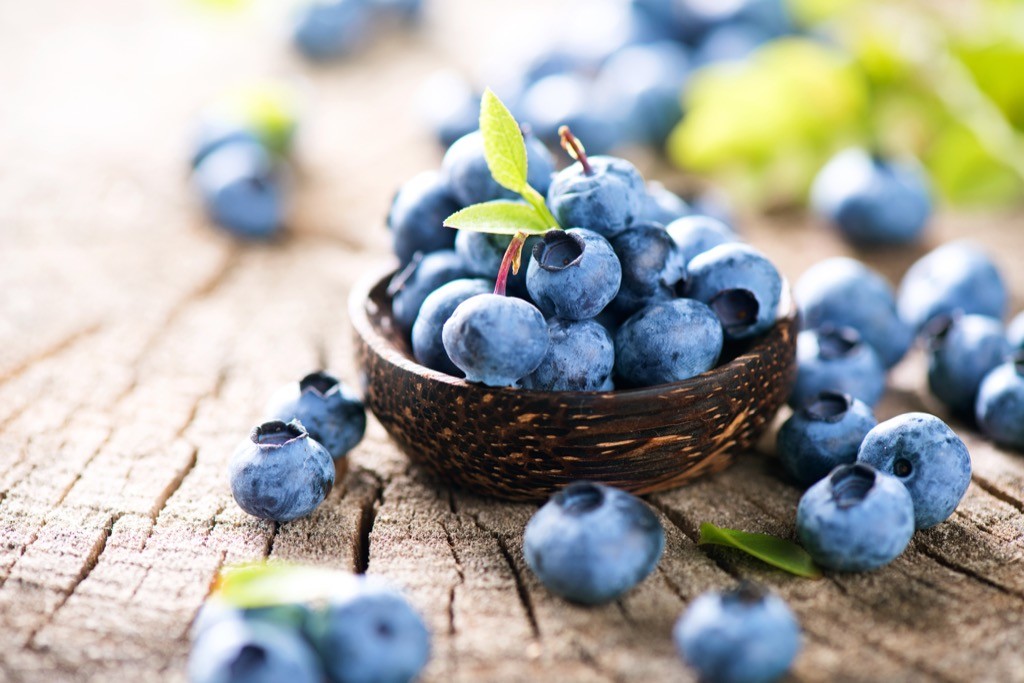 Blueberries in a bowl on a wooden surface