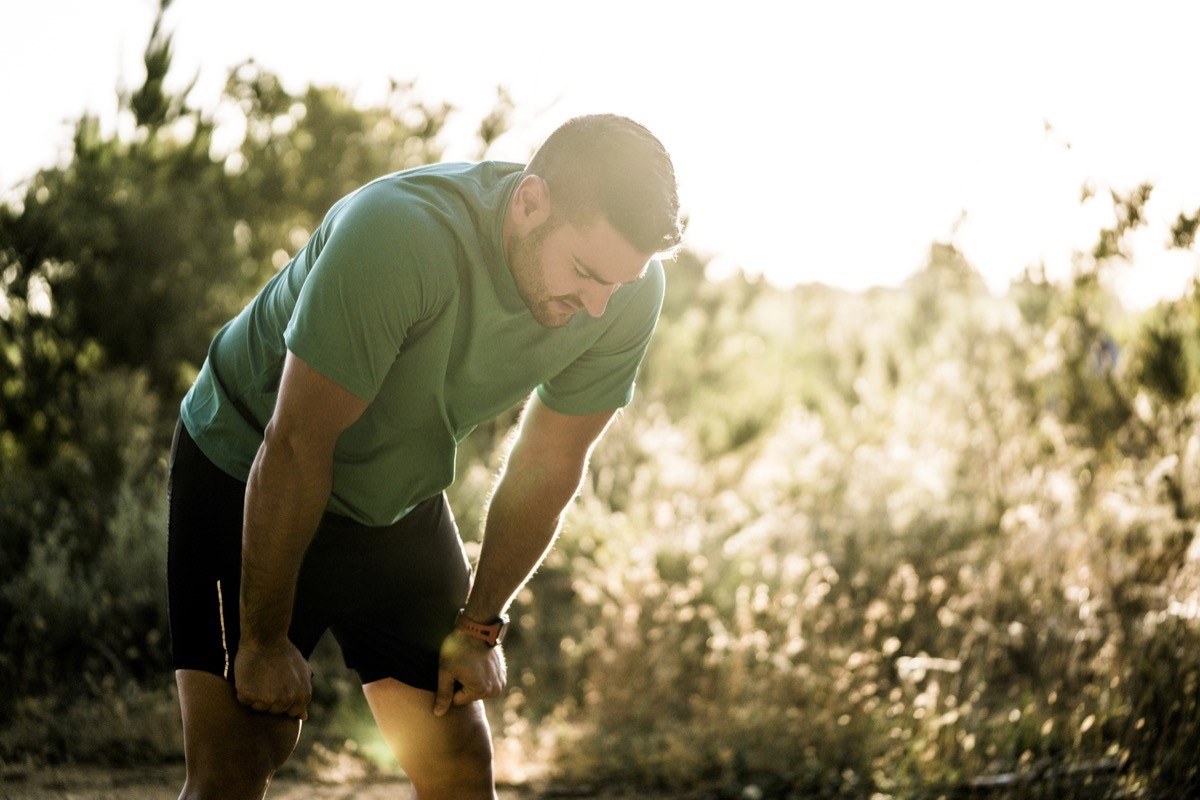 Tired male runner stopping to rest