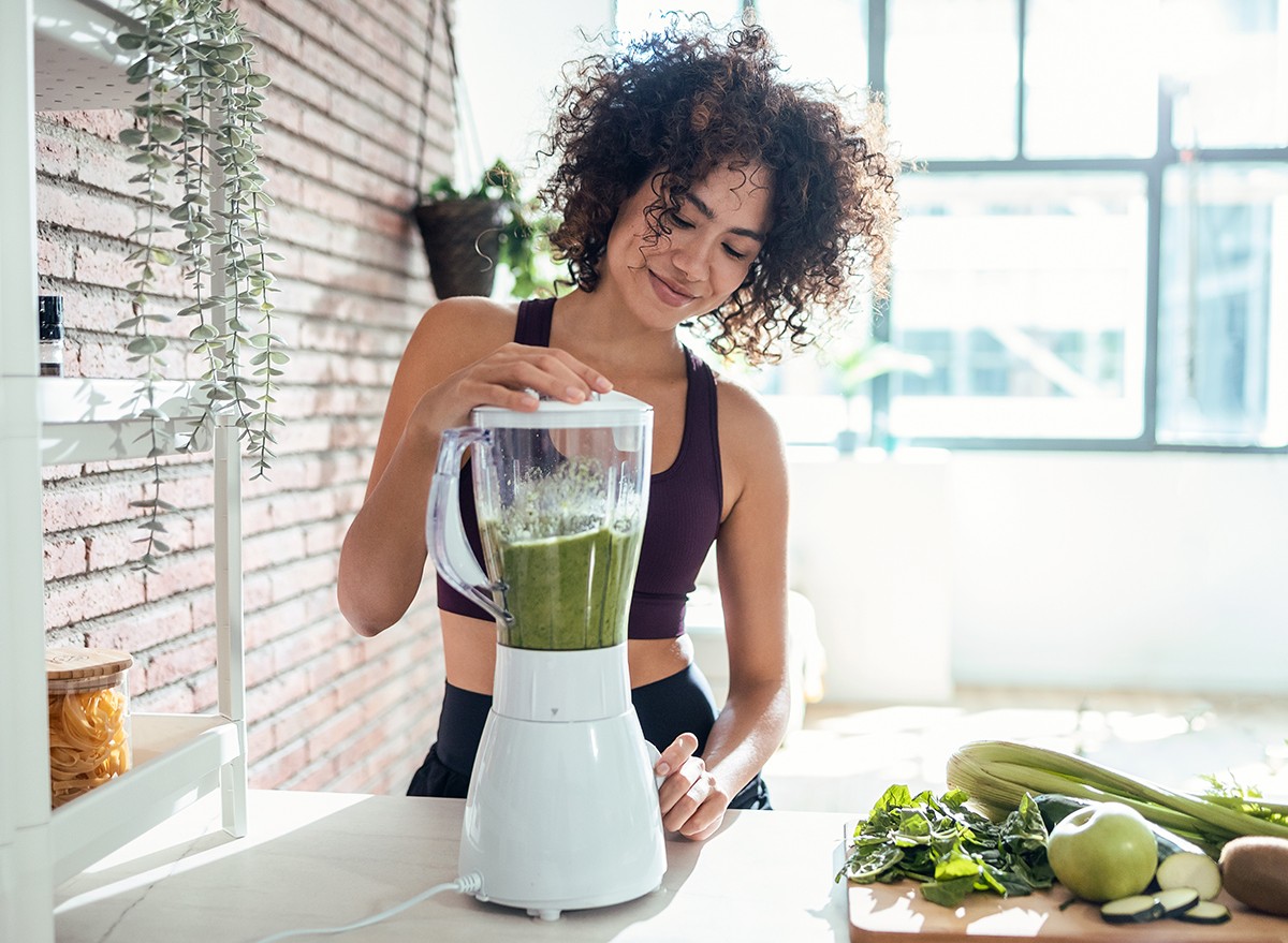 A woman making a smoothie in her kitchen at home 