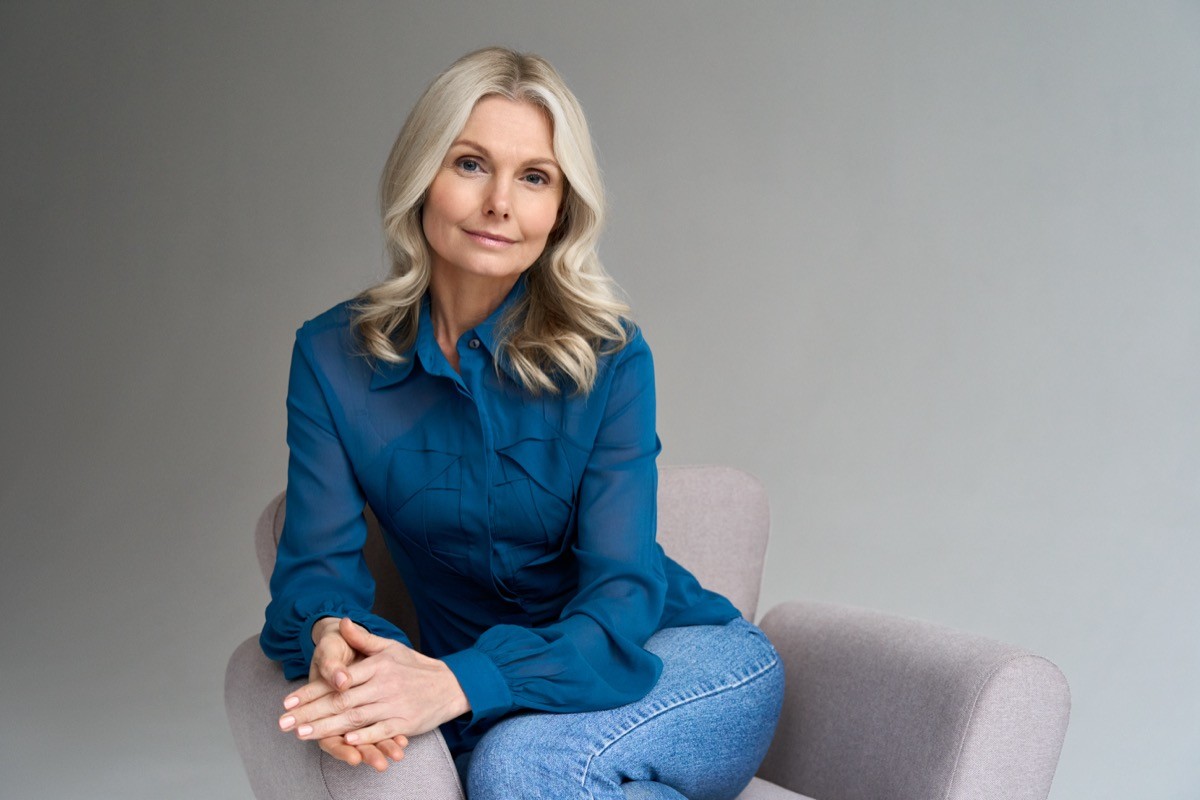 A confident female therapist sits in a chair in her office