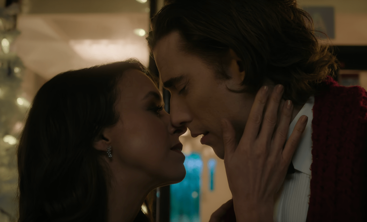 Actors Lacey Chabert and Dustin Milligan kissing in a still from Netflix's movie Hot Frosty