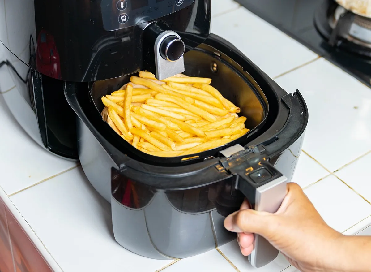 An air fryer with a basket full of french fries