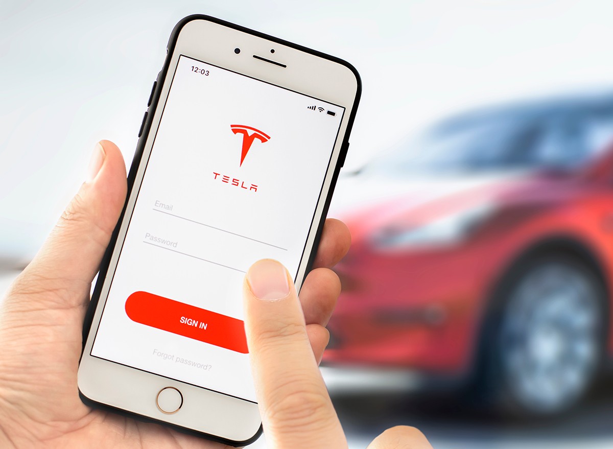 A man using the Tesla mobile app on his phone