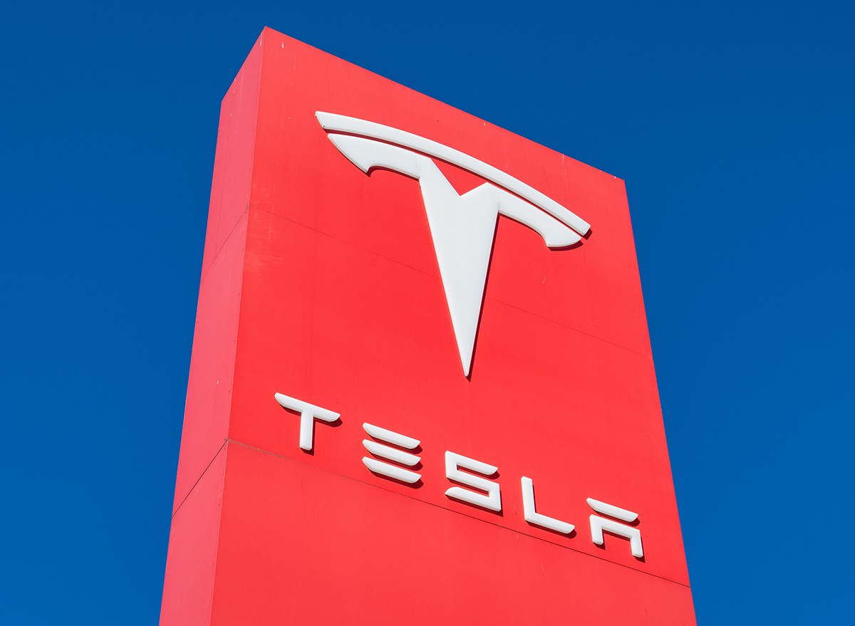 A Tesla sign against a blue sky