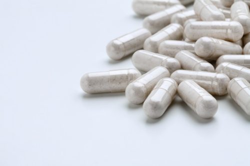 pile of Probiotics Supplements on white background