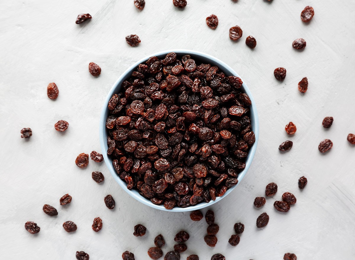 A bowl of raisins on a white surface