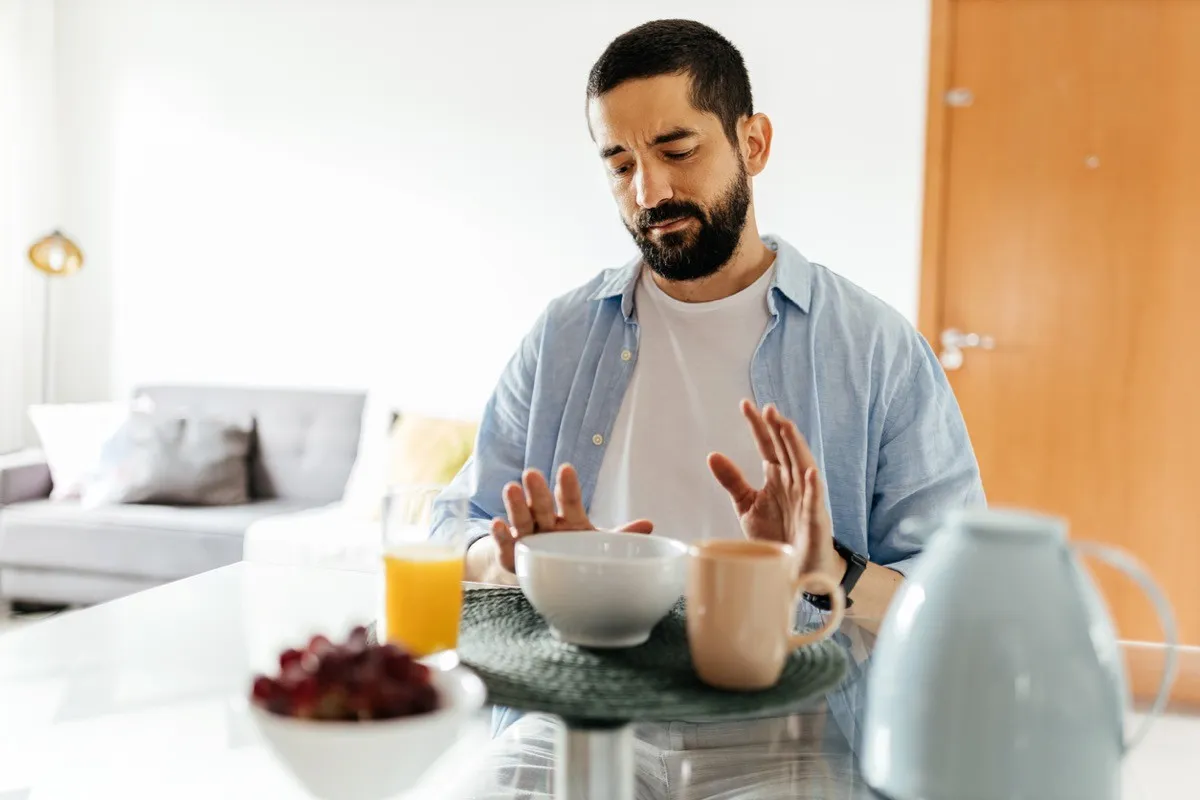 man at the table suffering from lack of appetite