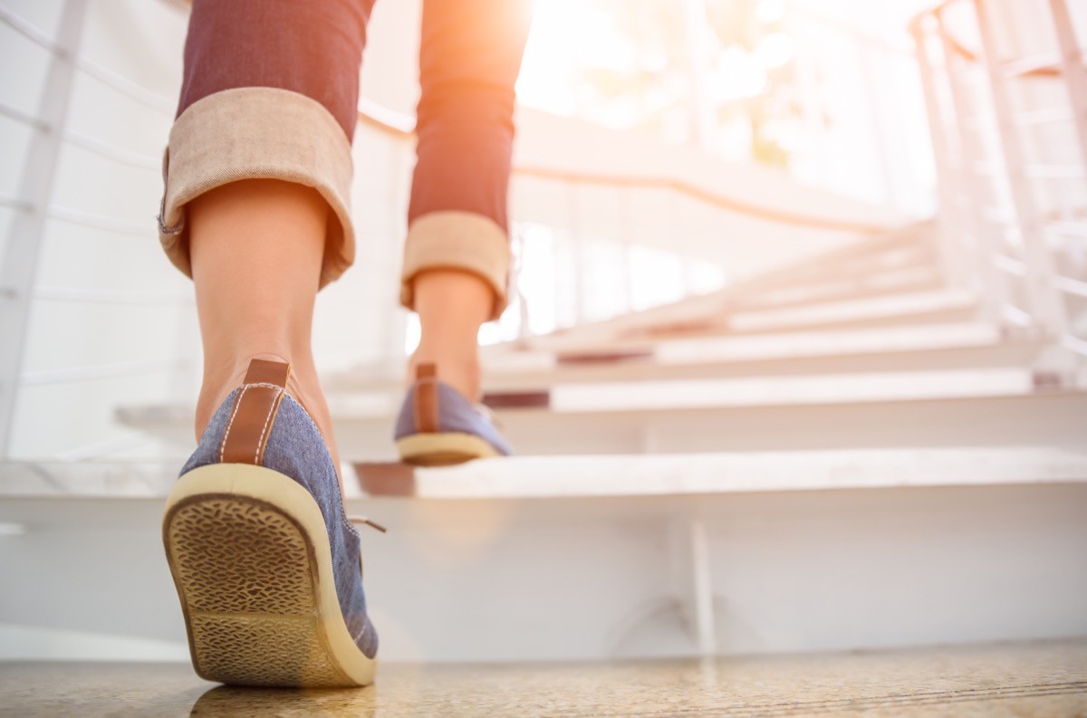 Young adult woman walking up the stairs