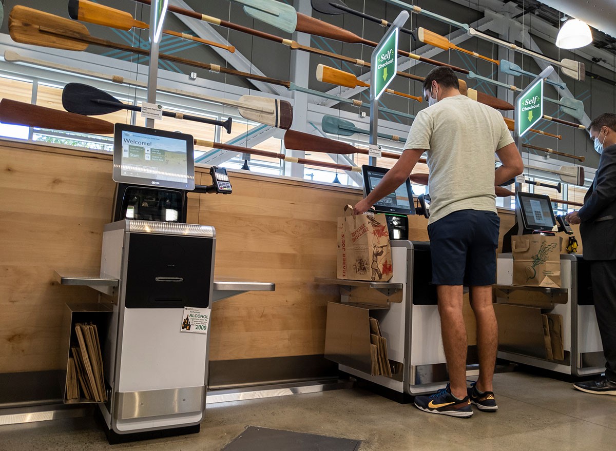 A man uses the self-checkout kiosks at Whole Foods