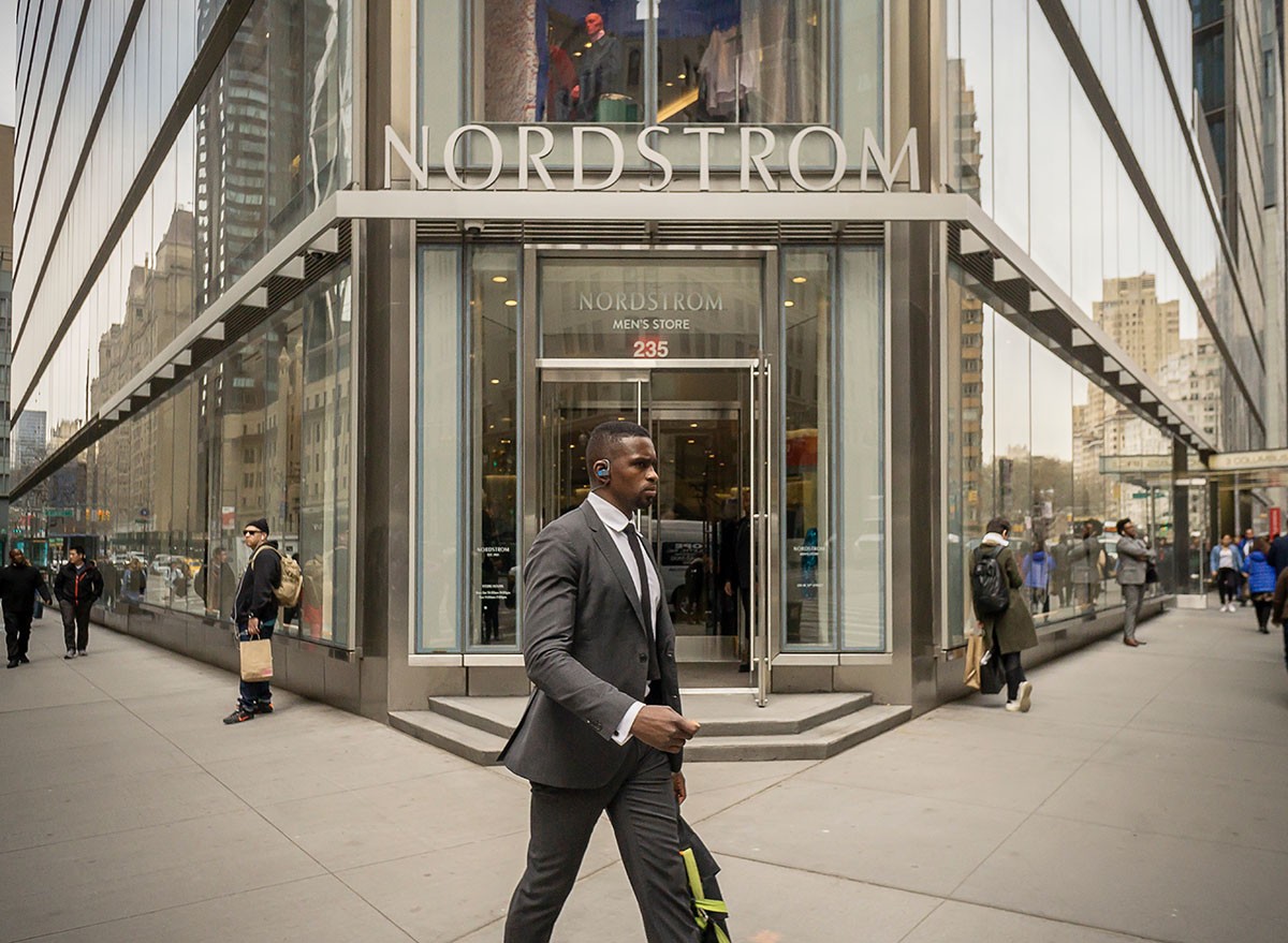 People walking on the street in front of a Nordstrom store